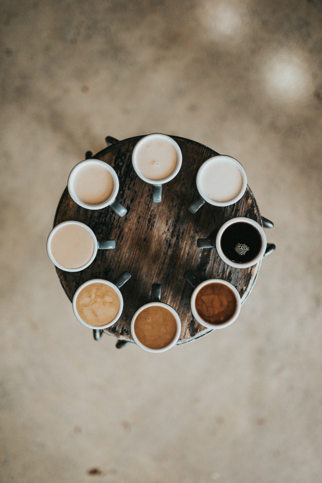 flat-lay-photography-of-eight-coffee-latte-in-mugs-on-round-table-pmw4jzelqcw
